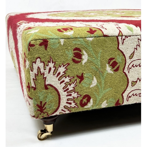 509 - HEARTH STOOL, 37cm H x 115cm W x93cm D, red and green crewel work covered on brass cstors.