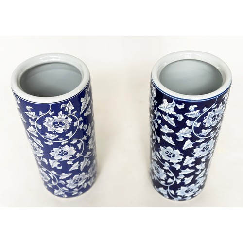 117 - STICK STANDS, a pair, Chinese blue and white ceramic, cylindrical with indigo blue ground, 45cm. (2)