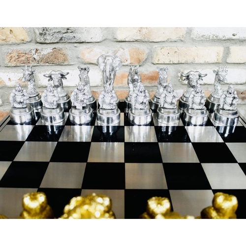 489 - CHESS SET, with silvered and gilt finish animal form pieces, 60cm x 60cm.