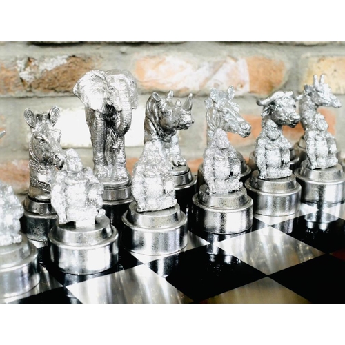 489 - CHESS SET, with silvered and gilt finish animal form pieces, 60cm x 60cm.