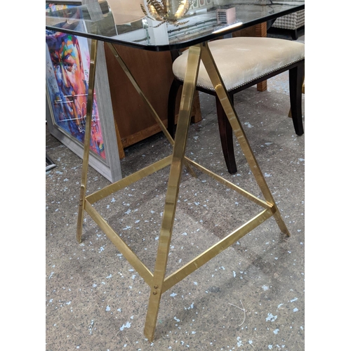 313 - TRESTLE DESK, 167cm x 84cm x 79cm, the glass top on gilt metal trestles.