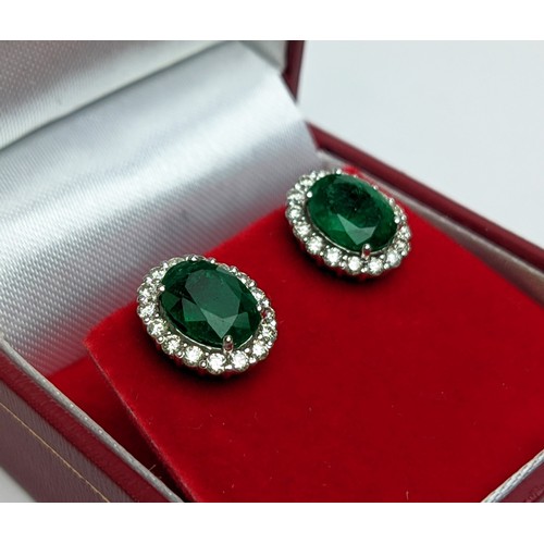 42 - A PAIR OF 18CT WHITE GOLD EMERALD AND DIAMOND STUD EARRINGS, the central emerald stones of 2.76 cara... 