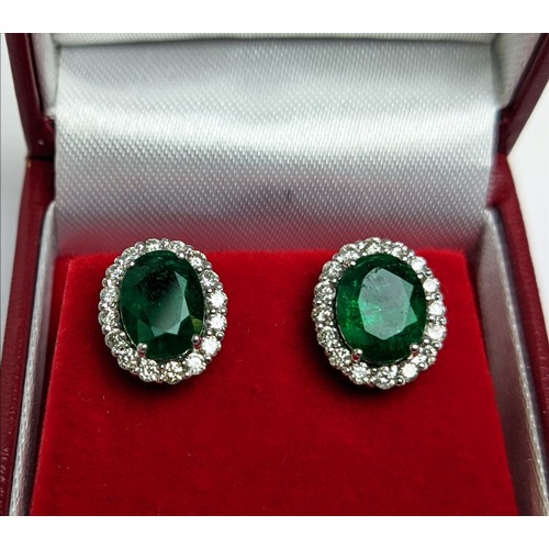 42 - A PAIR OF 18CT WHITE GOLD EMERALD AND DIAMOND STUD EARRINGS, the central emerald stones of 2.76 cara... 