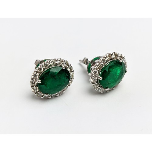 42 - A PAIR OF 18CT WHITE GOLD EMERALD AND DIAMOND STUD EARRINGS, the central emerald stones of 2.76 cara... 