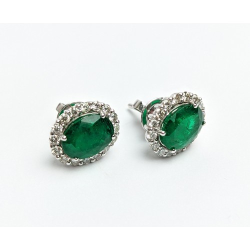 42 - A PAIR OF 18CT WHITE GOLD EMERALD AND DIAMOND STUD EARRINGS, the central emerald stones of 2.76 cara... 