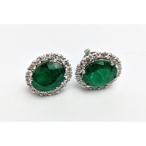 42 - A PAIR OF 18CT WHITE GOLD EMERALD AND DIAMOND STUD EARRINGS, the central emerald stones of 2.76 cara... 