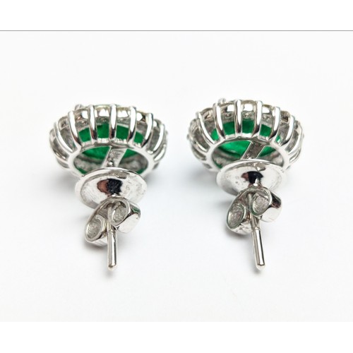 42 - A PAIR OF 18CT WHITE GOLD EMERALD AND DIAMOND STUD EARRINGS, the central emerald stones of 2.76 cara... 