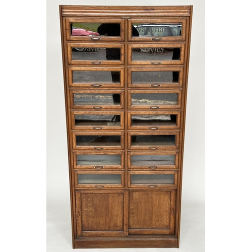 246 - HABERDASHERY CABINET BY DUDLEY & CO, mid 20th century oak with sixteen glazed drawers above two slid... 