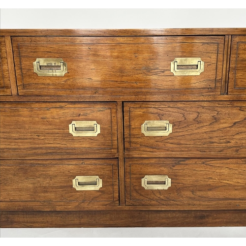 252 - LOW CHEST, campaign style elm and brass bound with seven drawers, 143cm x 46cm x 73cm H.