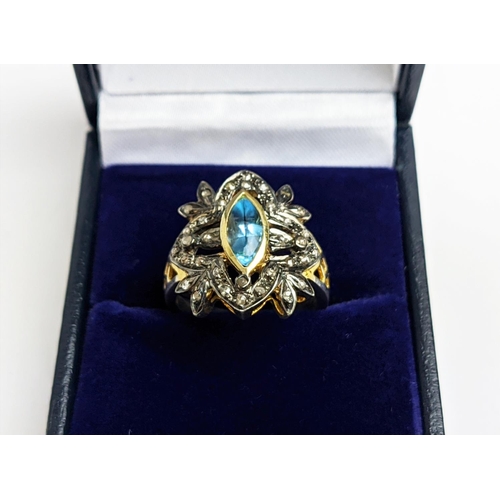 44 - A VICTORIAN STYLE SILVER-GILT TOPAZ DRESS RING, the central stone of 0.30 carats surrounded by tiny ... 