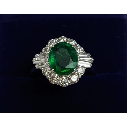 51 - AN 18CT WHITE GOLD EMERALD AND DIAMOND CLUSTER RING, the oval stone of approx. 1.89 carats, surround... 