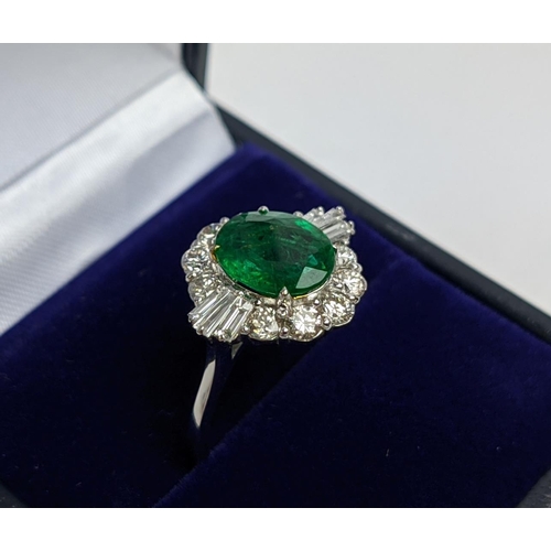 51 - AN 18CT WHITE GOLD EMERALD AND DIAMOND CLUSTER RING, the oval stone of approx. 1.89 carats, surround... 