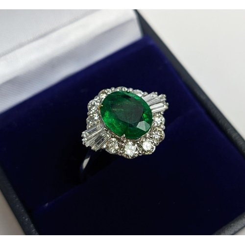 51 - AN 18CT WHITE GOLD EMERALD AND DIAMOND CLUSTER RING, the oval stone of approx. 1.89 carats, surround... 