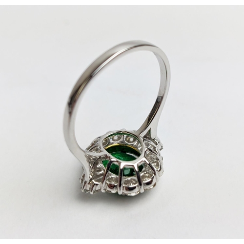 51 - AN 18CT WHITE GOLD EMERALD AND DIAMOND CLUSTER RING, the oval stone of approx. 1.89 carats, surround... 