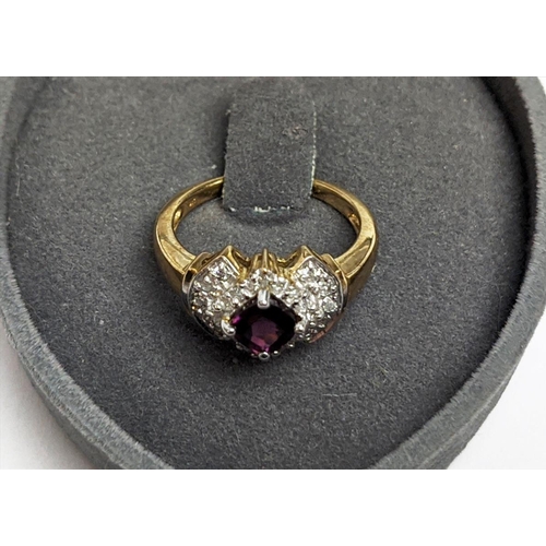 64 - A 9CT GOLD RHODOLITE GARNET SET DRESS RING, the central cushion cut stone of 0.50 carat, surrounded ... 