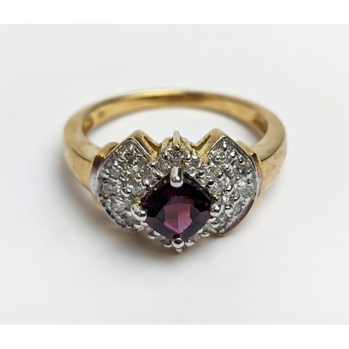 64 - A 9CT GOLD RHODOLITE GARNET SET DRESS RING, the central cushion cut stone of 0.50 carat, surrounded ... 