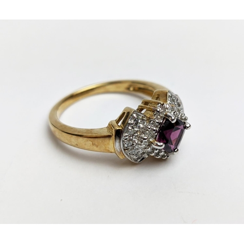 64 - A 9CT GOLD RHODOLITE GARNET SET DRESS RING, the central cushion cut stone of 0.50 carat, surrounded ... 