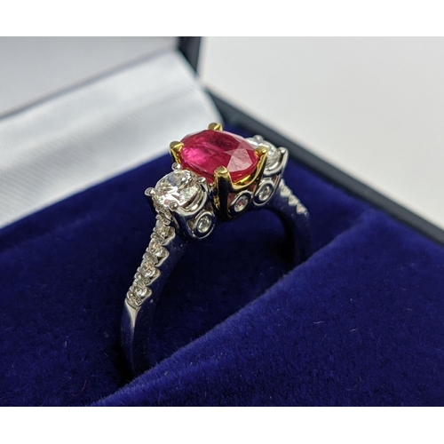 66 - AN 18CT WHITE GOLD RUBY AND DIAMOND TRILOGY RING, the central ruby stone of approx. 0.89 carat, diam... 