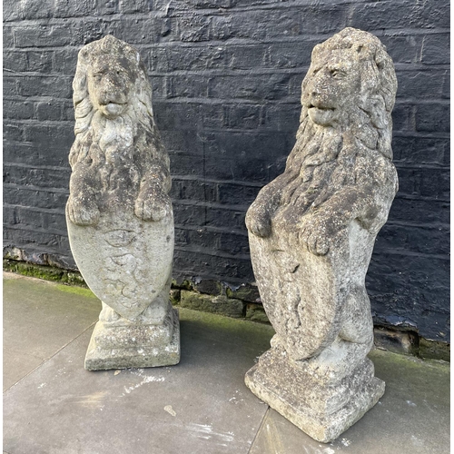 7 - HERALDIC LION STATUES, a pair, well weathered reconstituted stone, 83cm. (2)