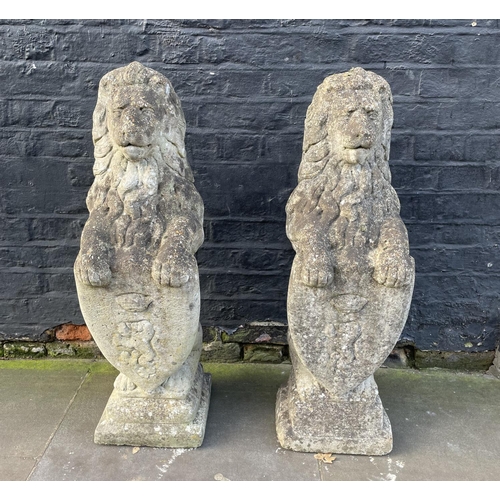 7 - HERALDIC LION STATUES, a pair, well weathered reconstituted stone, 83cm. (2)