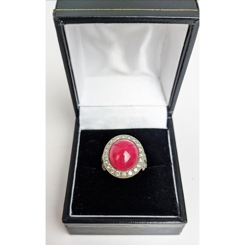 12 - RUBY AND DIAMOND DRESS RING, white metal shank, the central ruby cabochon of approx 10 carats, size ... 