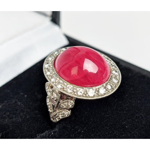 12 - RUBY AND DIAMOND DRESS RING, white metal shank, the central ruby cabochon of approx 10 carats, size ... 