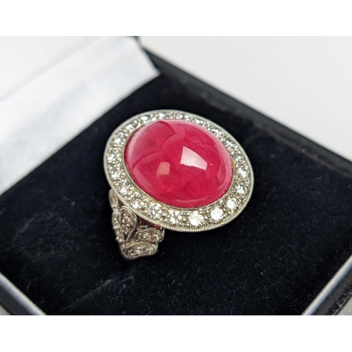 12 - RUBY AND DIAMOND DRESS RING, white metal shank, the central ruby cabochon of approx 10 carats, size ... 