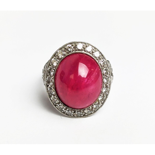 12 - RUBY AND DIAMOND DRESS RING, white metal shank, the central ruby cabochon of approx 10 carats, size ... 