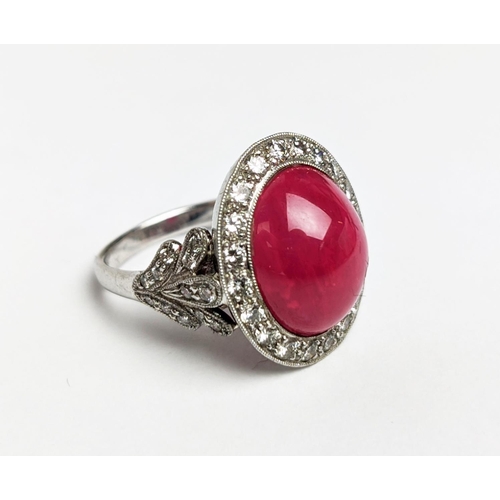 12 - RUBY AND DIAMOND DRESS RING, white metal shank, the central ruby cabochon of approx 10 carats, size ... 