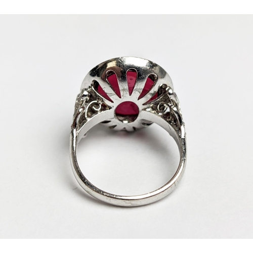 12 - RUBY AND DIAMOND DRESS RING, white metal shank, the central ruby cabochon of approx 10 carats, size ... 