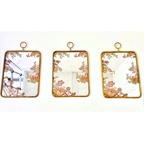 390 - WALL MIRRORS, a set of three, all with floral decoration, gilt frames, 64cm high, 40cm wide. (3)