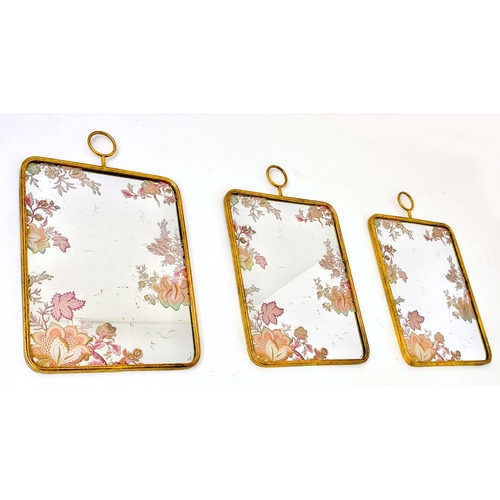 390 - WALL MIRRORS, a set of three, all with floral decoration, gilt frames, 64cm high, 40cm wide. (3)