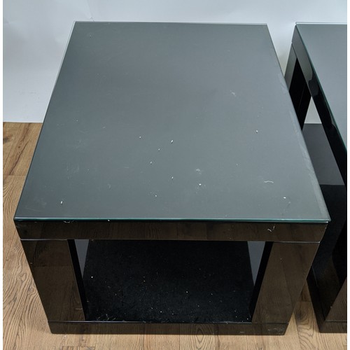 306 - LOW TABLES, a pair, black lacquered with glass tops, 85cm x 65cm x 51cm. (2)