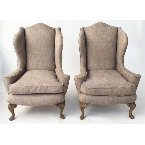 106 - WINGBACK ARMCHAIRS, a pair, Queen Anne style with natural linen upholstery and carved walnut cabrile... 