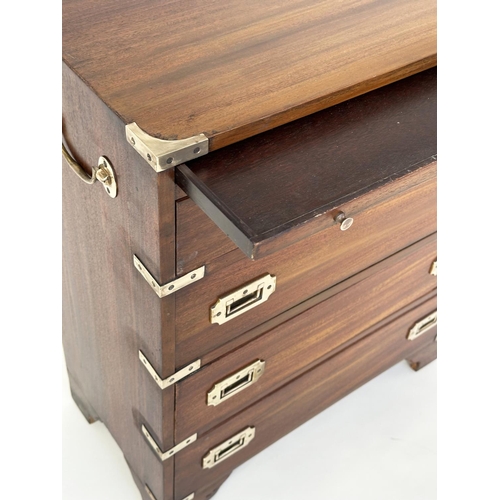 122 - CAMPAIGN STYLE CHESTS, a pair, mahogany and brass bound each with brushing slide above two short and... 