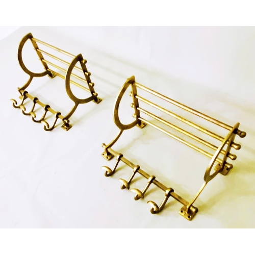 406 - WALL MOUNTING LUGGAGE RACKS, a pair, each with a rodded rack and four hooks, gilt metal, 35cm high, ... 