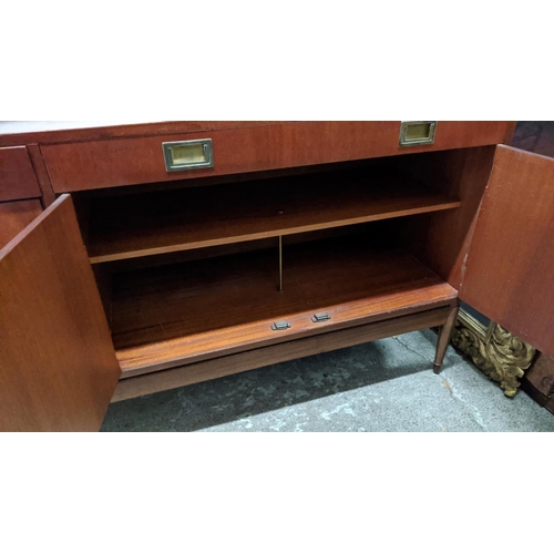 133 - SIDEBOARD, mid-century teak with two drawers above two cupboards, raised on brass caped tapered supp... 