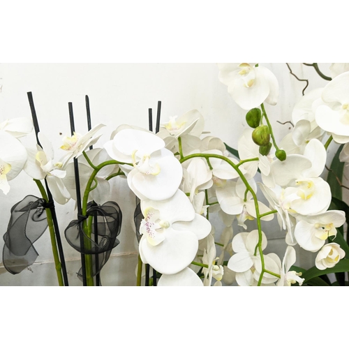 397 - FAUX ORCHID DISPLAYS, a collection of three, differing sizes and in differing vessels, 110cm at tall... 