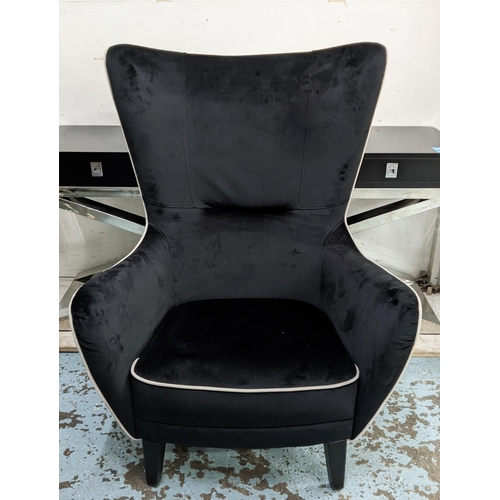 404 - WINGBACK ARMCHAIR, 82cm W, 1950s Italian style, black velvet upholstered, grey piping detail.