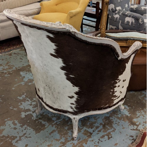 271 - BERGERE ARMCHAIR, in cowskin upholstery with carved distressed painted showframe, 80cm W.