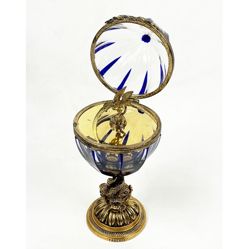2 - FABERGE EGG, number four, clear cut glass with blue inclusions on mythical entwined fish column, 25c... 