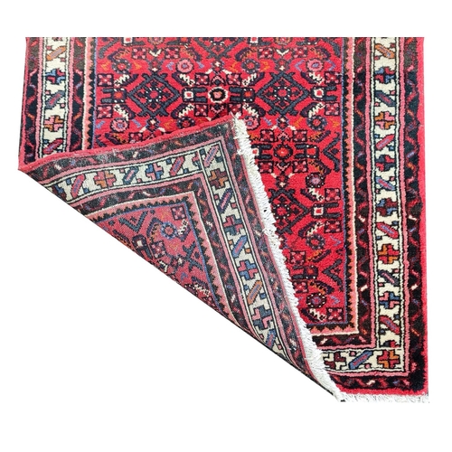 207A - LARGE PERSIAN HOSSEINABAD CRIMSON GROUND RUNNER, 514cm L x 84cm W.