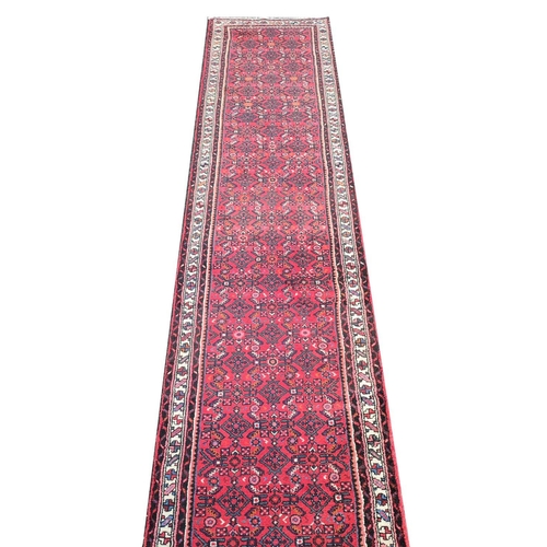 207A - LARGE PERSIAN HOSSEINABAD CRIMSON GROUND RUNNER, 514cm L x 84cm W.