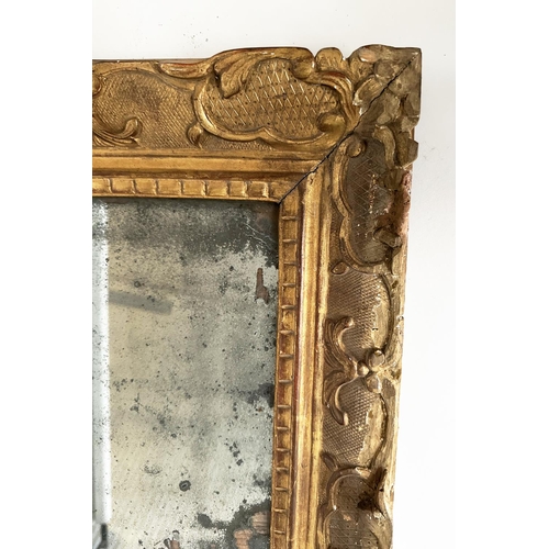 241 - WALL MIRROR, late 18th century French carved giltwood and gesso with foliate crest and distressed ea... 