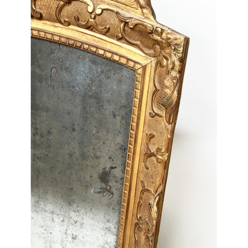 241 - WALL MIRROR, late 18th century French carved giltwood and gesso with foliate crest and distressed ea... 