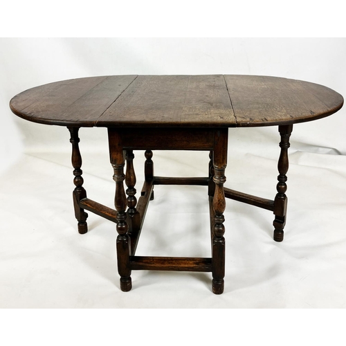 373 - AN OAK GATELEG DINING TABLE, traditionally made, oval top, turned supports, square stretchers, 72cm ... 