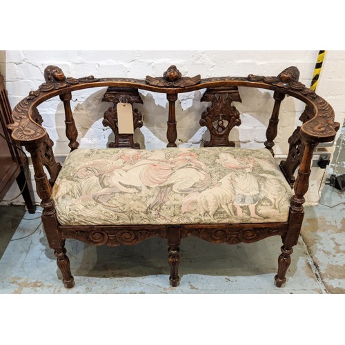 367 - A CONTINENTAL 19TH CENTURY WALNUT TWO SEATER HALL SEAT, cherub head decoration foliage carved rails,... 