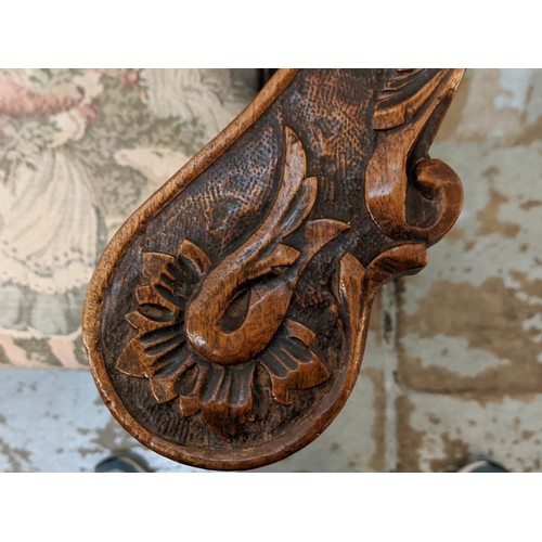 367 - A CONTINENTAL 19TH CENTURY WALNUT TWO SEATER HALL SEAT, cherub head decoration foliage carved rails,... 