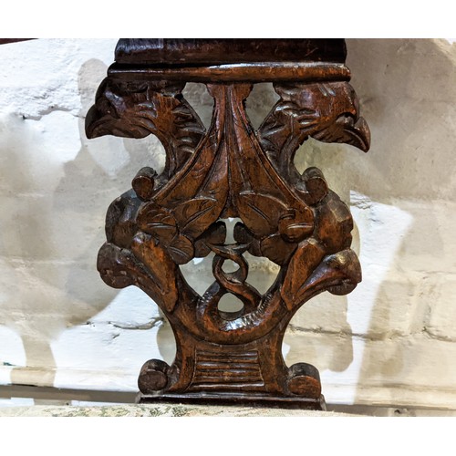 367 - A CONTINENTAL 19TH CENTURY WALNUT TWO SEATER HALL SEAT, cherub head decoration foliage carved rails,... 