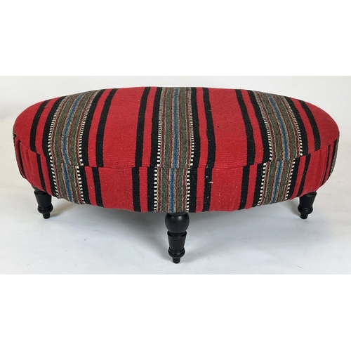 223 - HEARTH STOOL, 43cm H x 116cm W x 73cm D, ebonised of oval form in striped red flatweave upholstery.